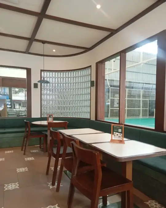 Kedai Sesama dining room with green banquettes